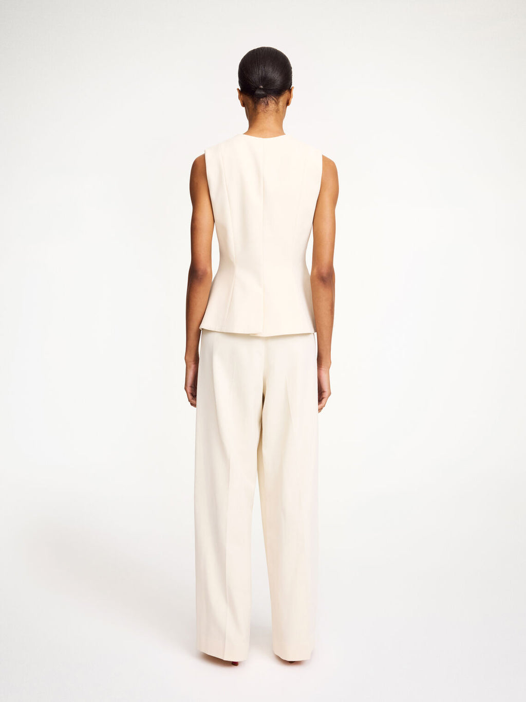 By Malene Birger Merlin vest i hvit, med feminine detaljer og en innsvinget midje, laget av resirkulert polyester, viskose og elastan.