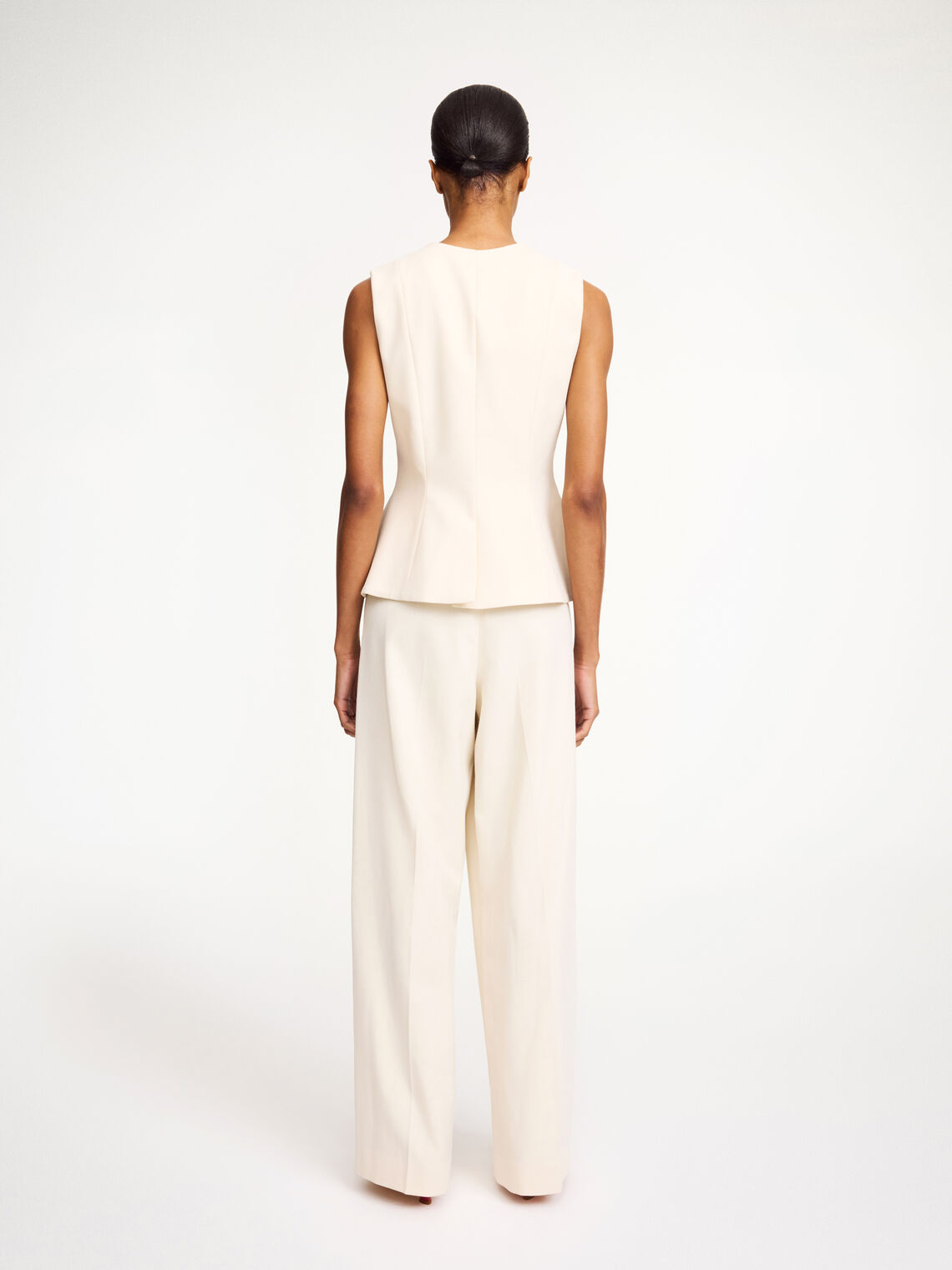 By Malene Birger Merlin vest i hvit, med feminine detaljer og en innsvinget midje, laget av resirkulert polyester, viskose og elastan.