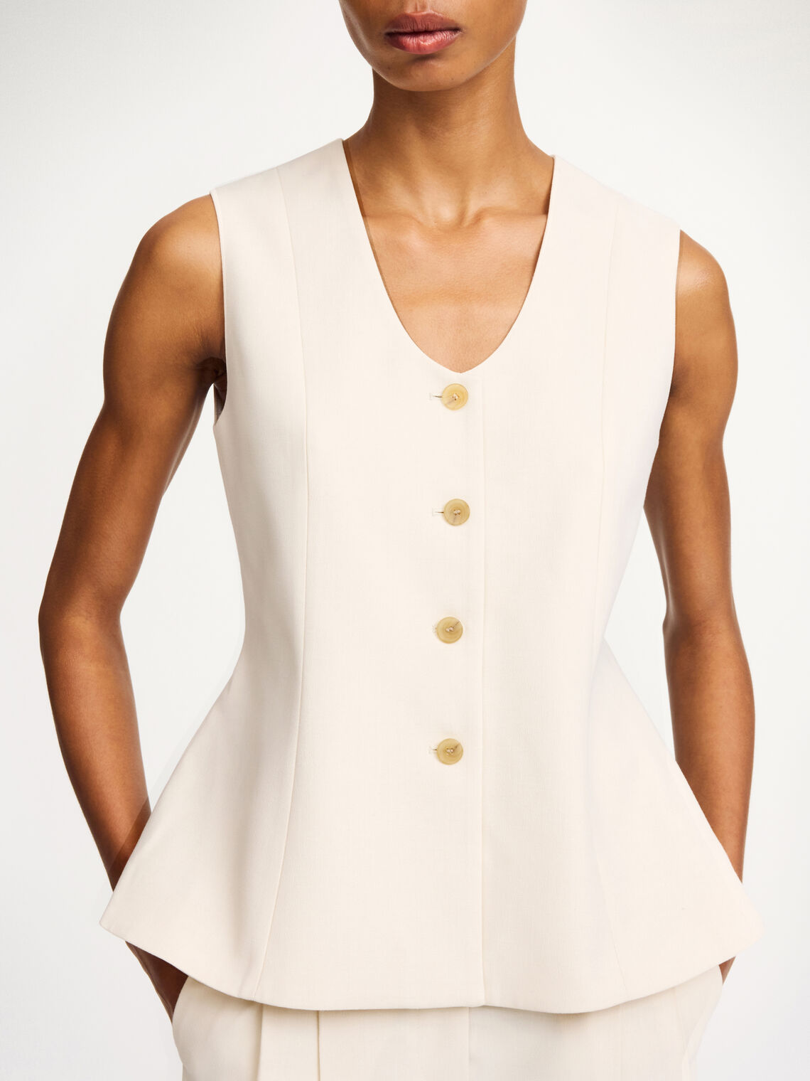 By Malene Birger Merlin vest i hvit, med feminine detaljer og en innsvinget midje, laget av resirkulert polyester, viskose og elastan.