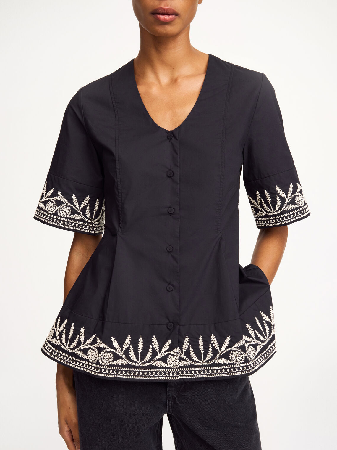 By Malene Birger Merlina bluse i sort, laget av 100% bomull, med broderier, dyp utringning og en feminin passform.