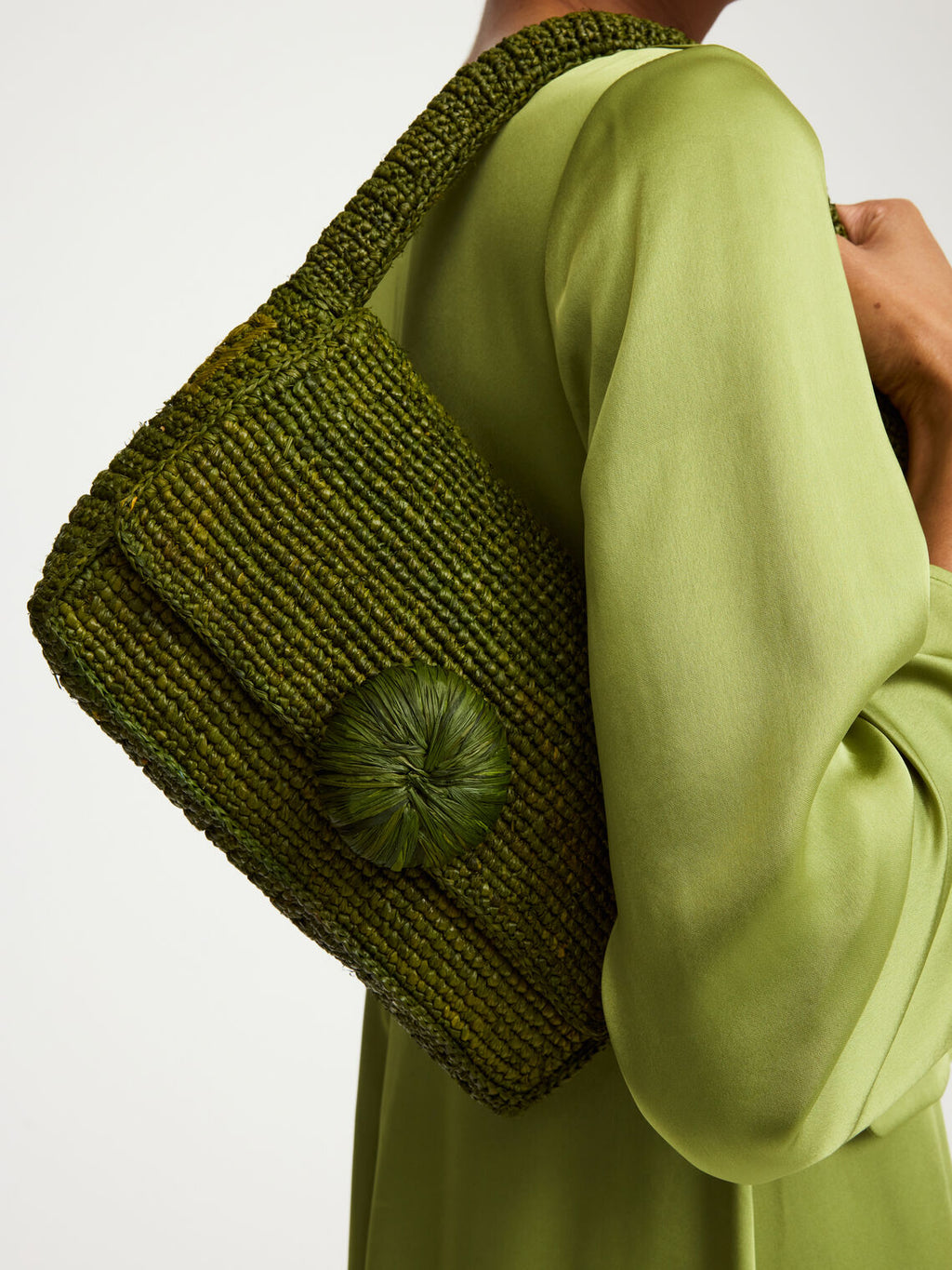 By Malene Birger Miro veske grønn i 100% strå, med brodert monogram og en blomsterknopp-detalj i front.