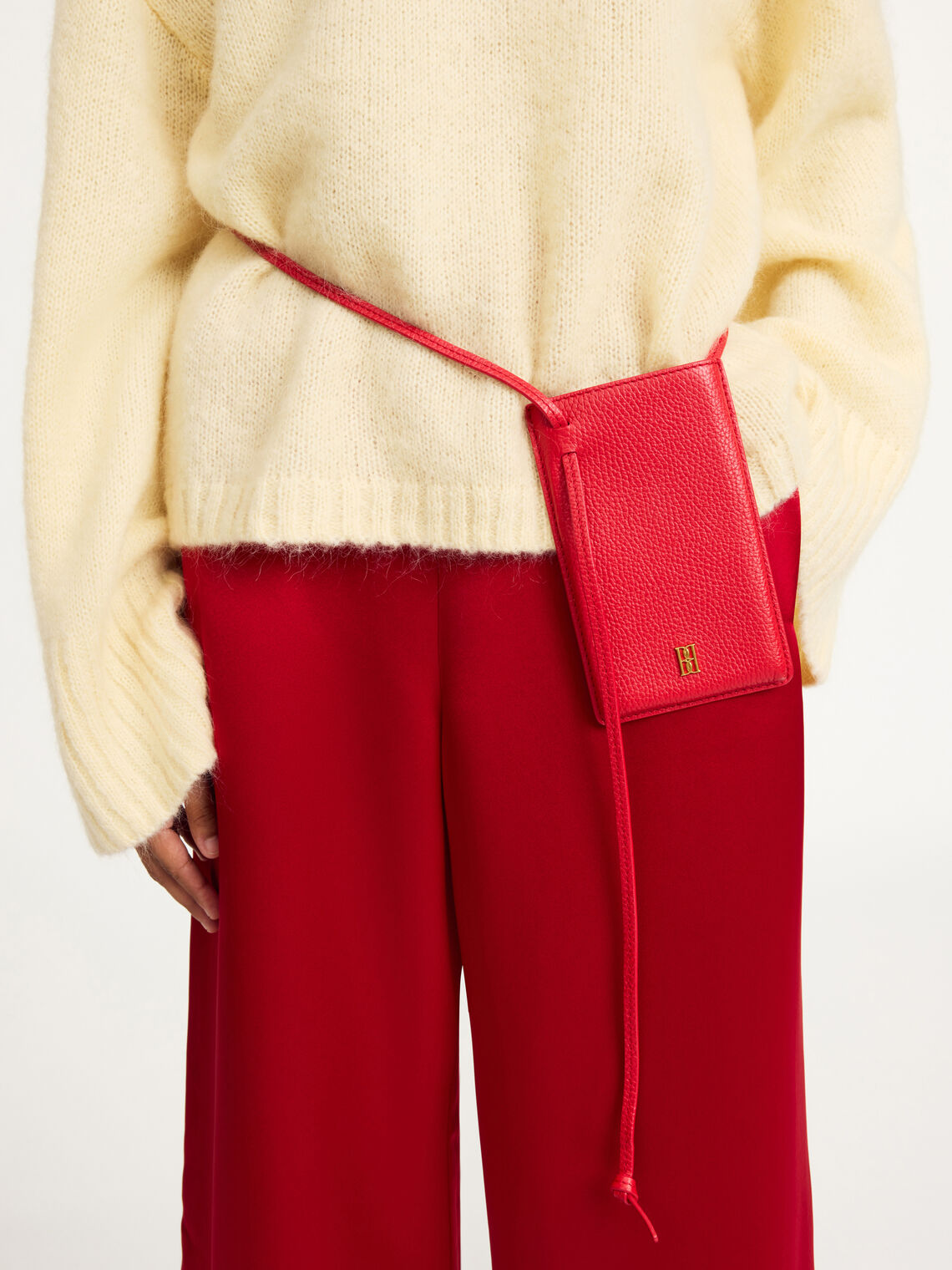 By Malene Birger mobilveske i rød, resirkulert skinn, med monogram-motiv og knutedetalj.