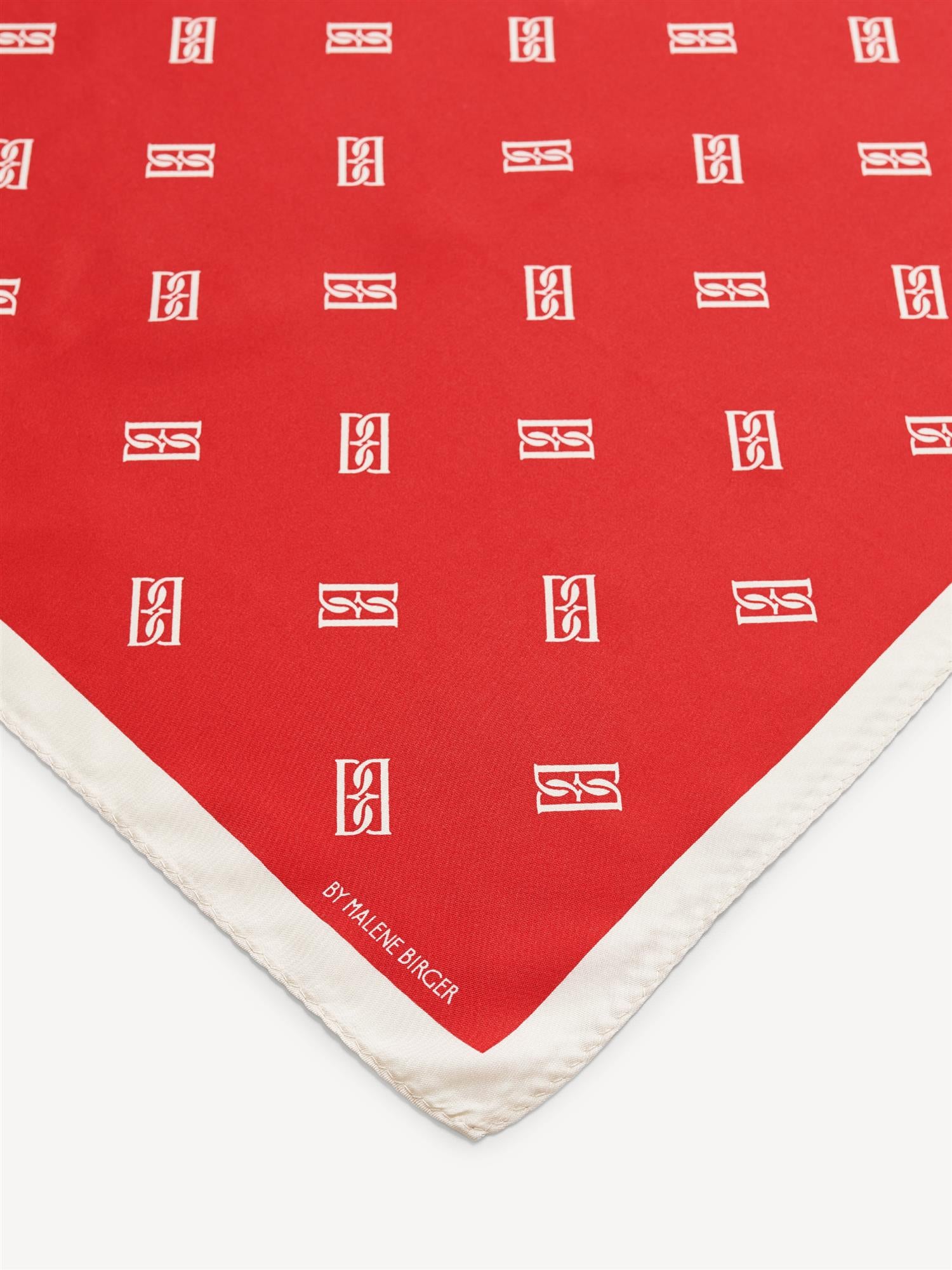 By Malene Birger Monnas skjerf i rød silke, med BB monogram-mønster.