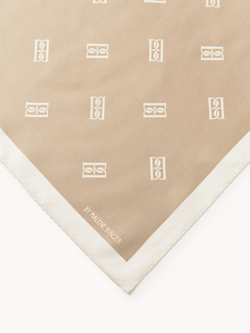 By Malene Birger Monnis silkeskjerf i lysebrun, laget av 100% silke med monogram-print.