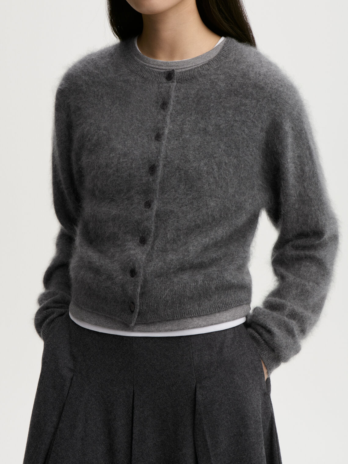 MONTANA cardigan fra By Malene Birger i fargen mørkegrå, laget i 100% cashmere. Rund hals, ribbestrikkede avslutninger og lukkes med knapper i front.