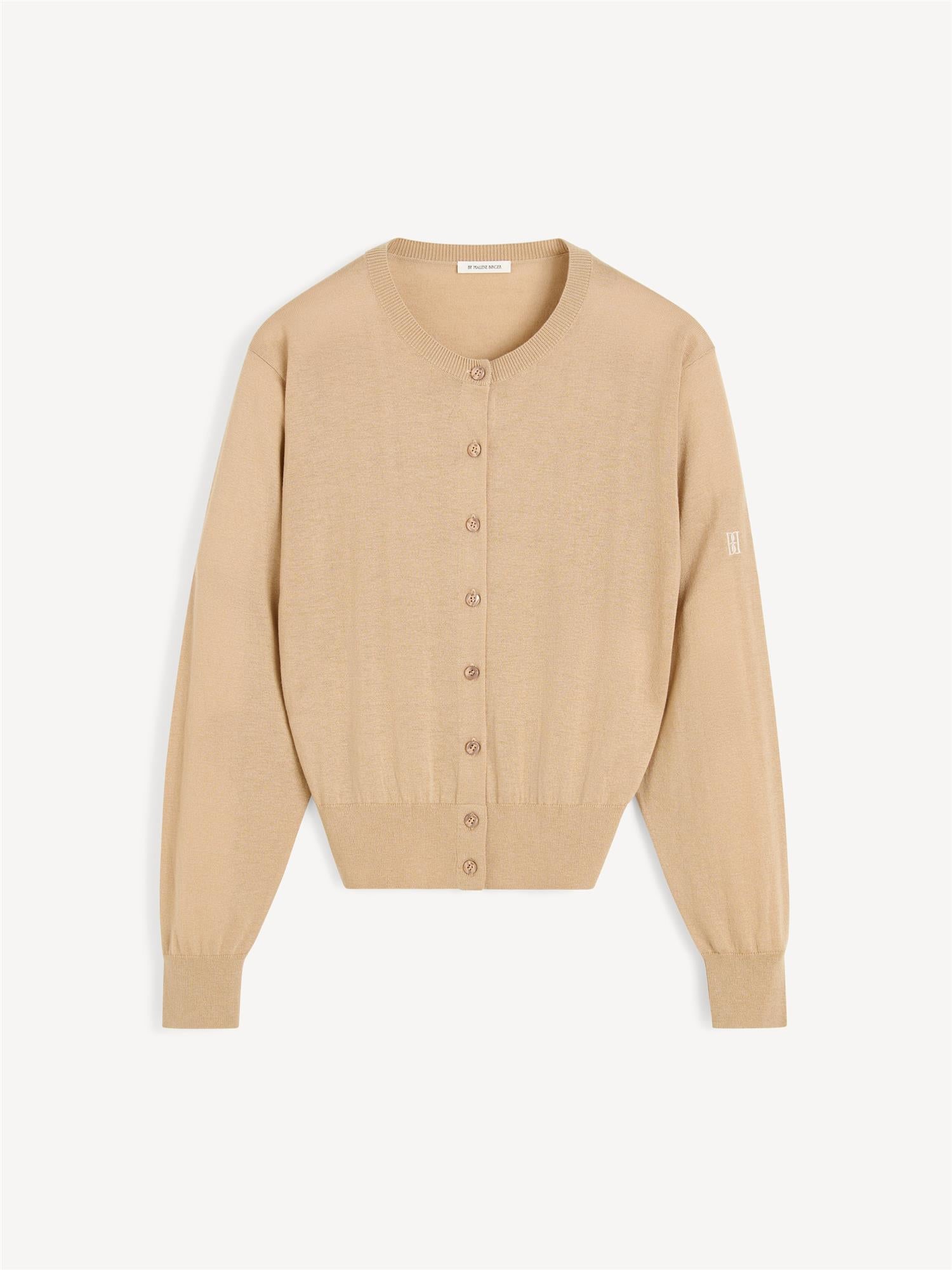 By Malene Birger Montie cardigan i beige, med ribbestrikkede kanter, rund hals og laget av en blanding av ull, silke og lyocell.