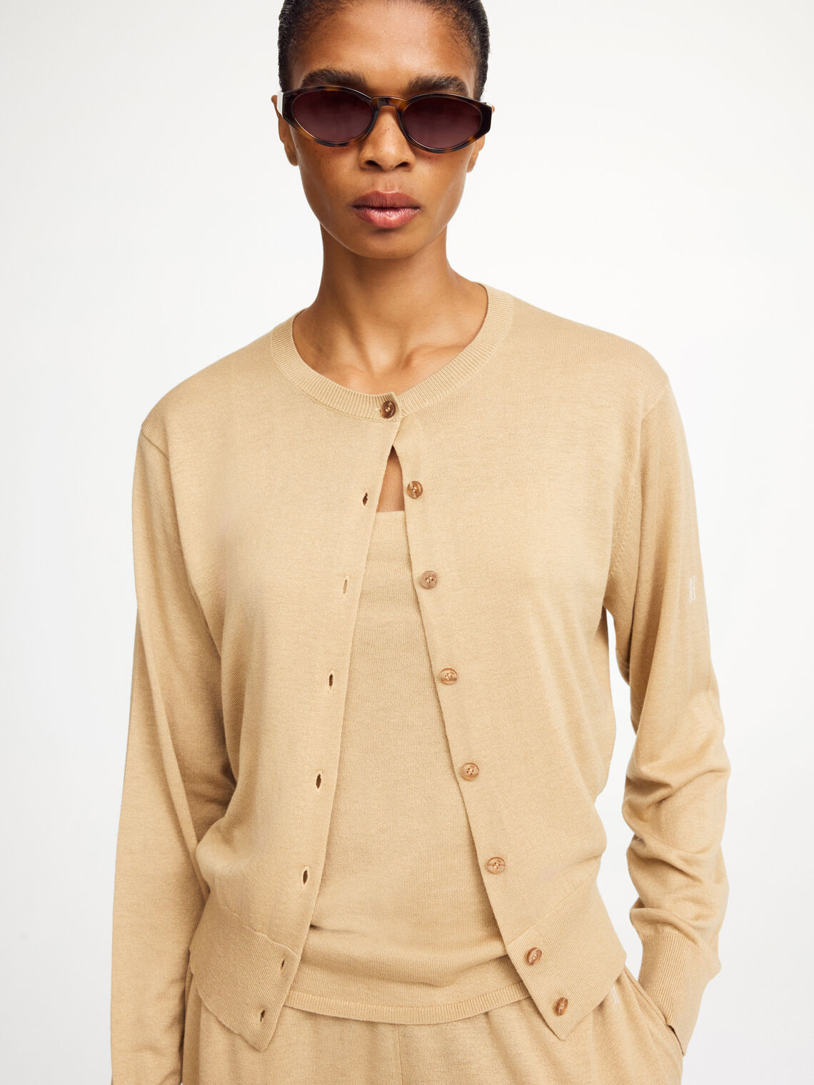 By Malene Birger Montie cardigan i beige, med ribbestrikkede kanter, rund hals og laget av en blanding av ull, silke og lyocell.