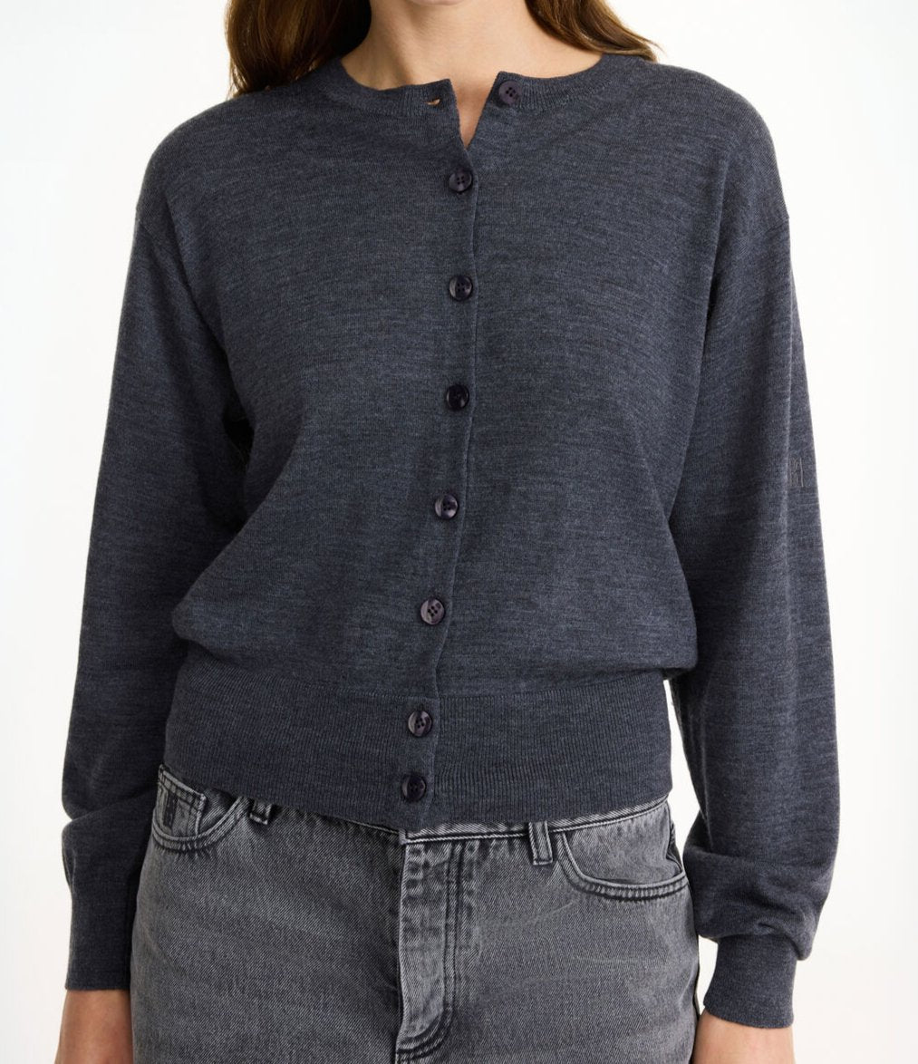 By Malene Birger Montie cardigan i koksgrå, med ribbestrikkede kanter, rund hals og laget av 100% merinoull.