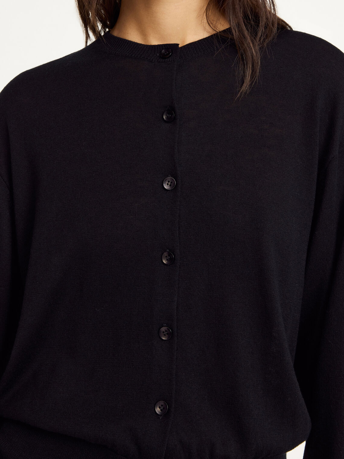 Nærbilde av sort MONTIE cardigan med ribbestrikkede kanter og knapperekke i lyocell, ull og silke.
