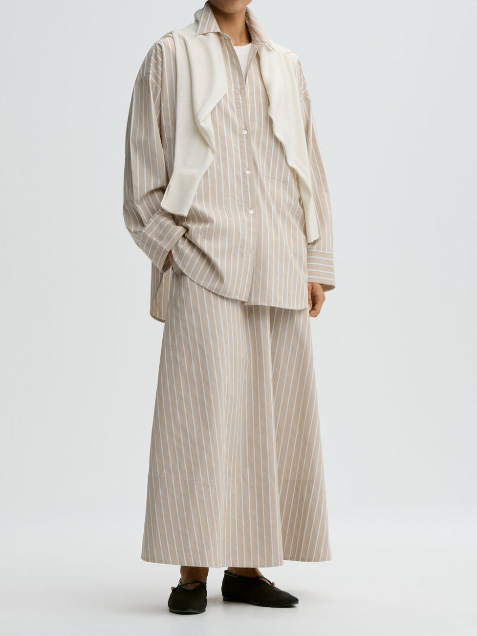 By Malene Birger Pheobes beige bomullsskjørt, løs A-formet silhuett med lommer i siden.