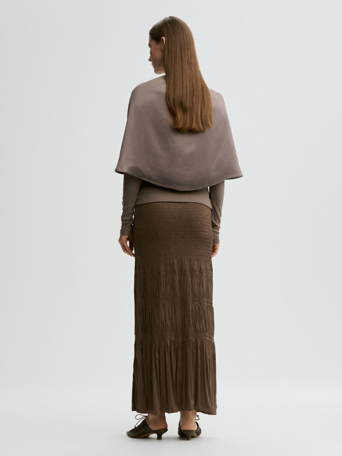 By Malene Birger PINLOS cape i brun materiale med Signatur Flower-print. Rund halsringning og lange fallende linjer.