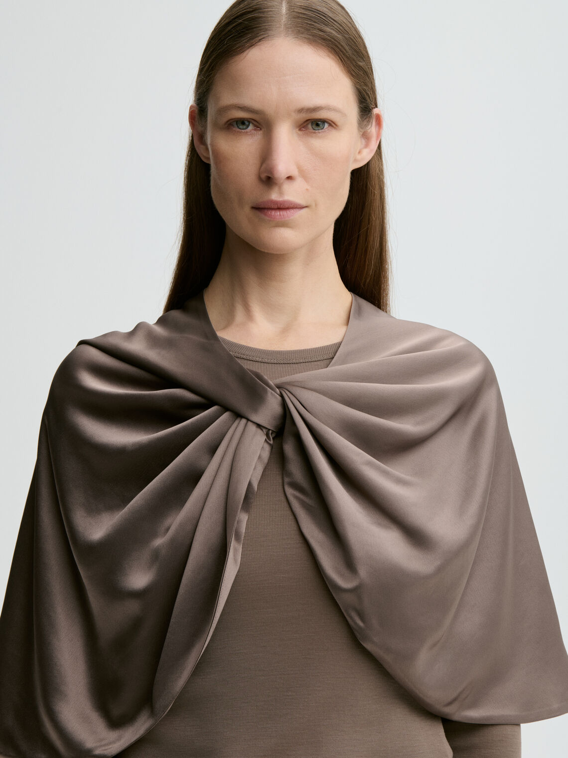 By Malene Birger PINLOS cape i brun materiale med Signatur Flower-print. Rund halsringning og lange fallende linjer.