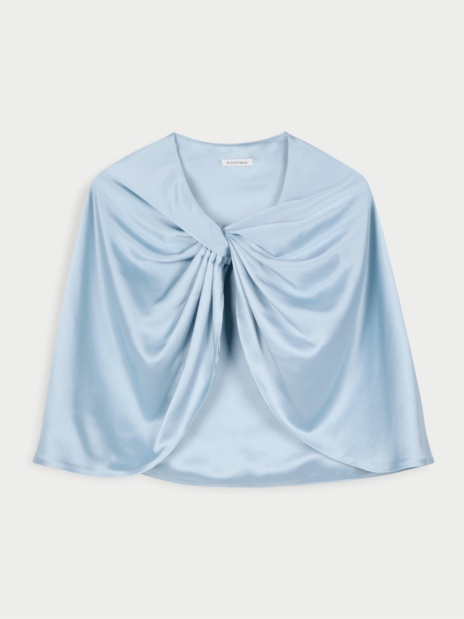 By Malene Birger PINLOS cape i lyseblå materiale med Signatur Flower-print. Rund halsringning og lange elegante fallende linjer.