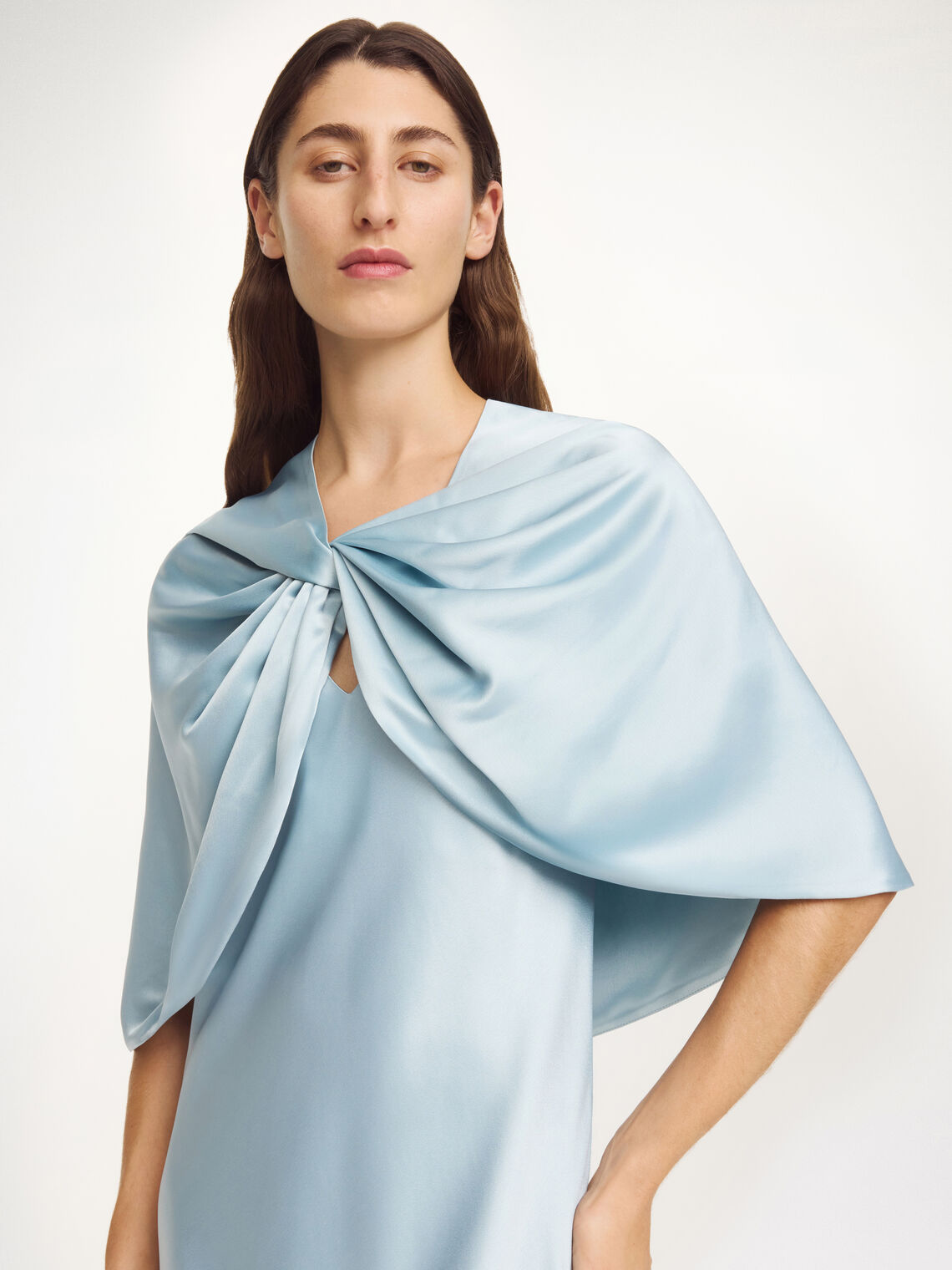 By Malene Birger PINLOS cape i lyseblå materiale med Signatur Flower-print. Rund halsringning og lange elegante fallende linjer.