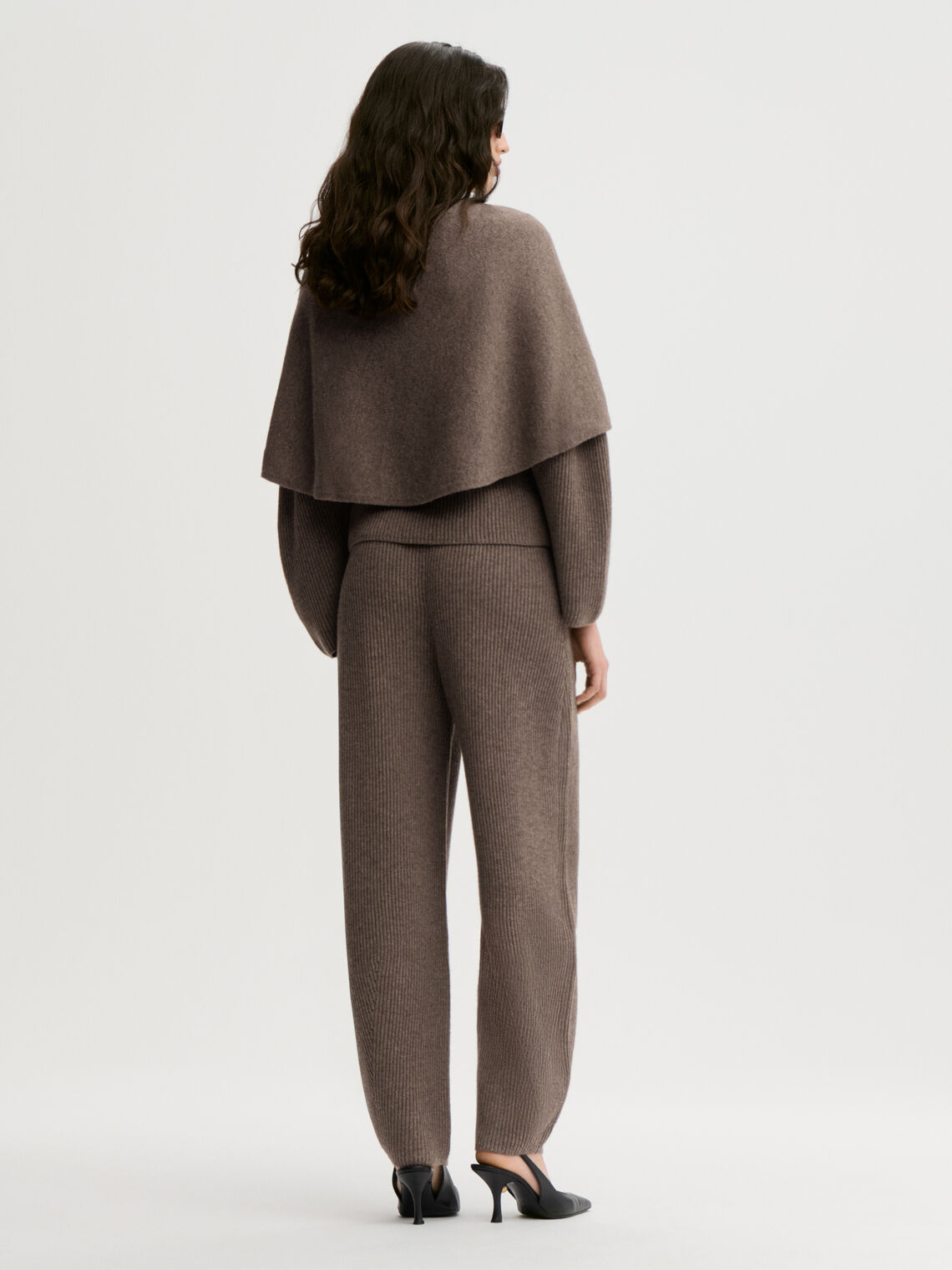 PINNE cape fra By Malene Birger i fargen brun, laget i 75% merinoull og 25% yak. Knytedetalj i front som kan brukes foran, på siden eller bak.