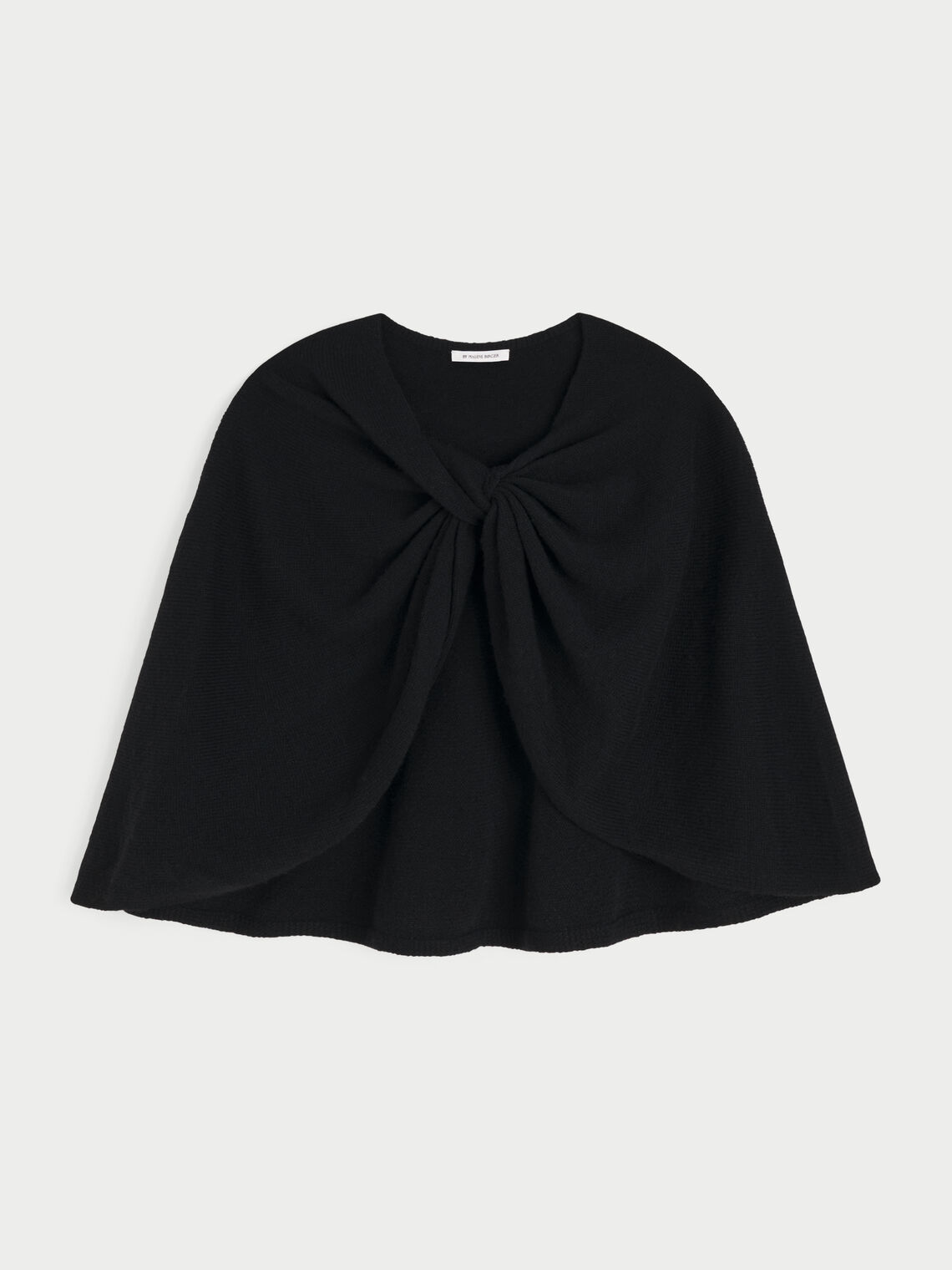 PINNE cape fra By Malene Birger i fargen sort, laget i 75% merinoull og 25% yak. Knytedetalj i front som kan brukes foran, på siden eller bak.