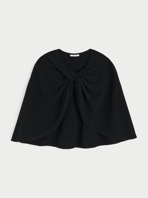 PINNE cape fra By Malene Birger i fargen sort, laget i 75% merinoull og 25% yak. Knytedetalj i front som kan brukes foran, på siden eller bak.