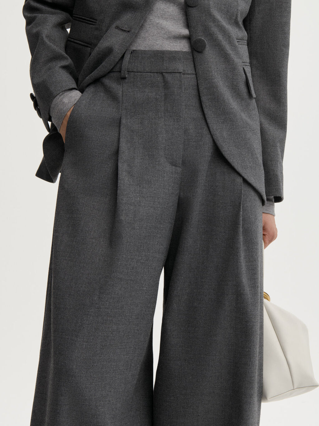 POVILANNA dressbukse fra By Malene Birger i fargen mørkegrå, laget i 69% resirkulert polyester, 30% viskose og 1% elastan. Skreddersydd look med høyt liv, legg i front og kongleformet passform.