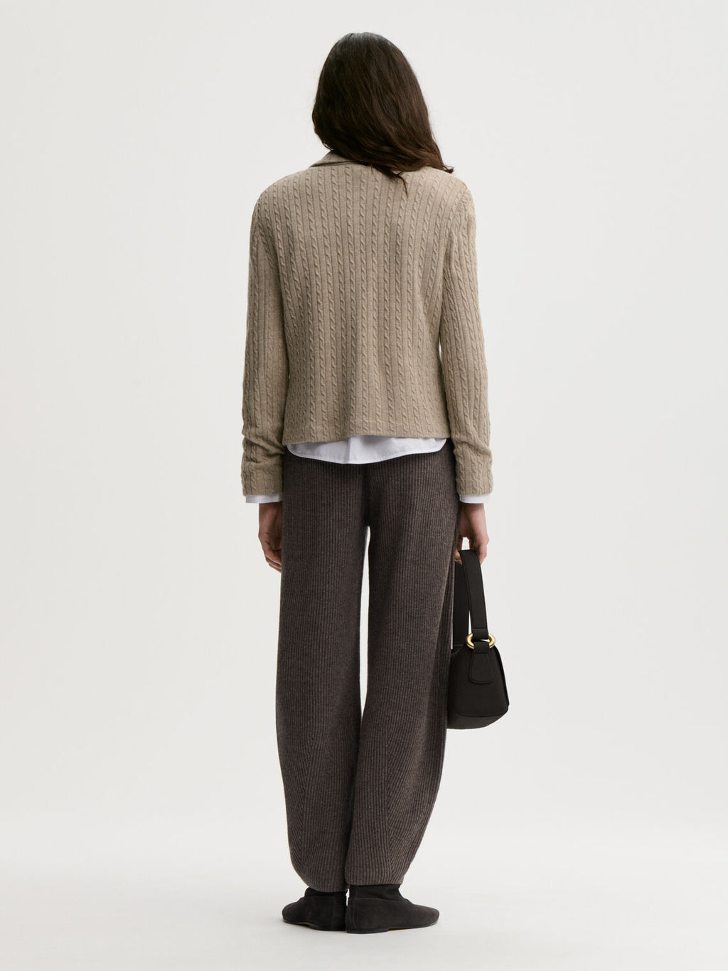 RIVA cardigan fra By Malene Birger i fargen beige, laget i 90% ull og 10% cashmere. Kabelstrikket struktur med v-hals, lommer i front, halvveis foret og cropped lengde.
