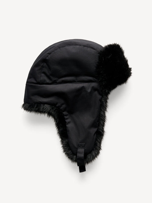 ROLLA vinterlue fra By Malene Birger i fargen sort, laget i vannavvisende 100% bomull med fuskepelskant. Klassisk flylue-silhuett med spenne under haken og brodert monogram.