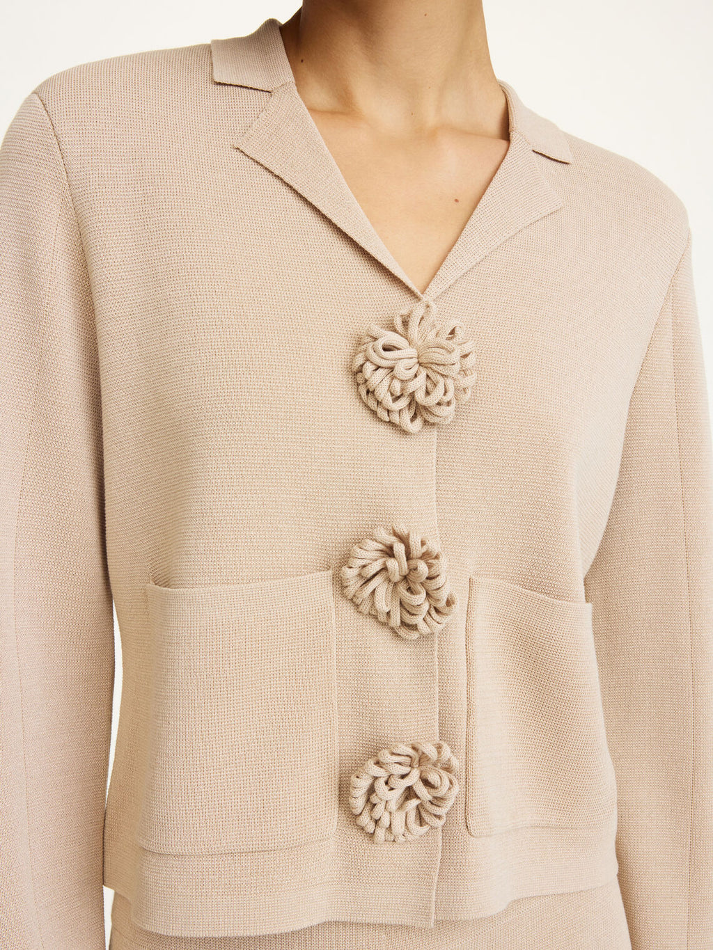By Malene Birger Rosa cardigan i beige, med blomsterknapper, cropped lengde og laget av viskose og polyamid.