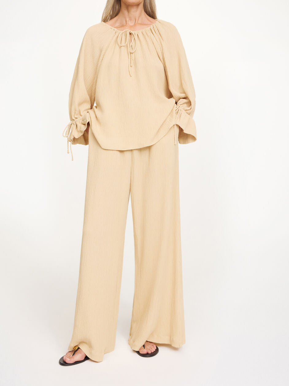 Beige ROSE WEAVE bluse fra By Malene Birger, sett forfra med v-hals og knyting i halsen.