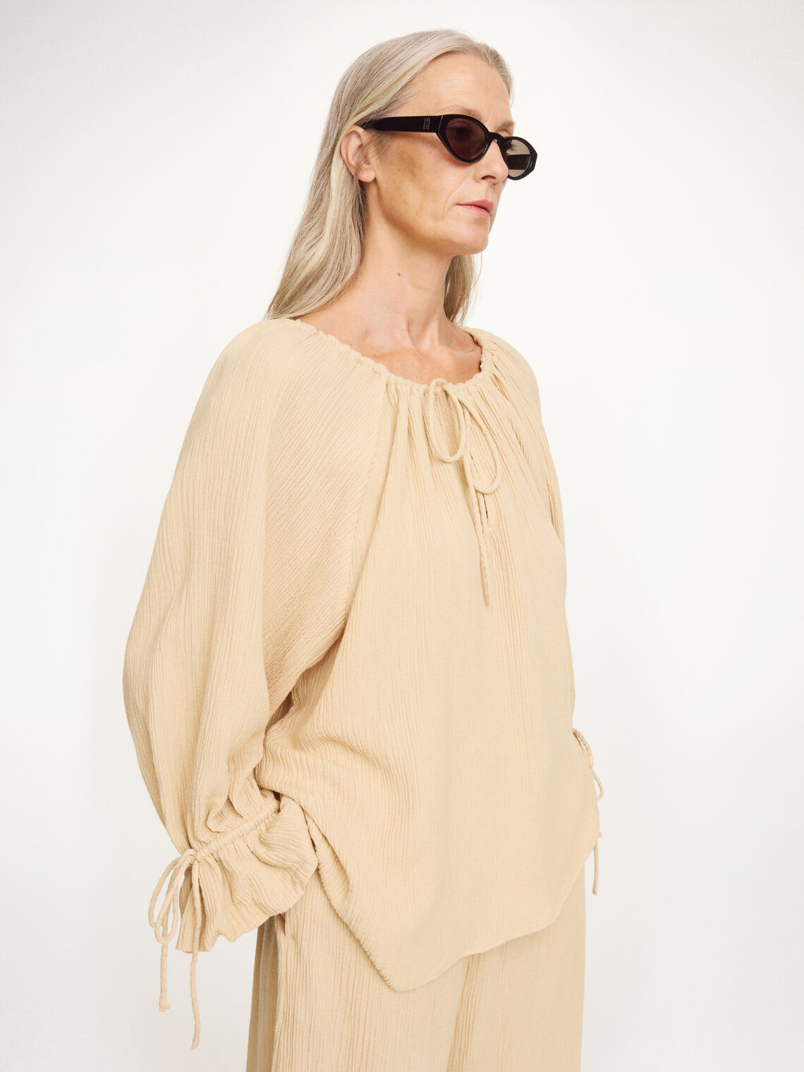 Beige ROSE WEAVE bluse fra By Malene Birger, oversized passform sett fra siden.