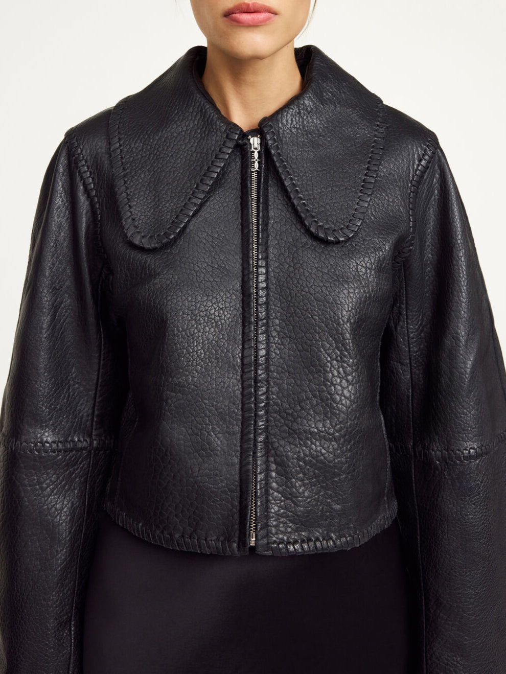 By Malene Birger Rowani kort skinnjakke i sort, laget av lammeskinn, med flettedetaljer og en cropped passform.