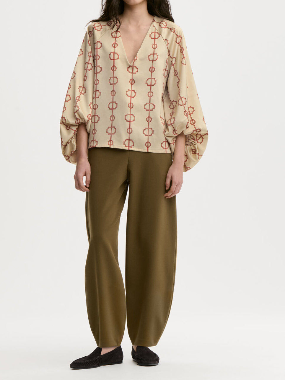 SALIA bluse fra By Malene Birger med egenutviklet print, laget i 85% acetat og 15% polyester. Raglanermer med ballongfasong, v-hals og strikk i mansjettene.