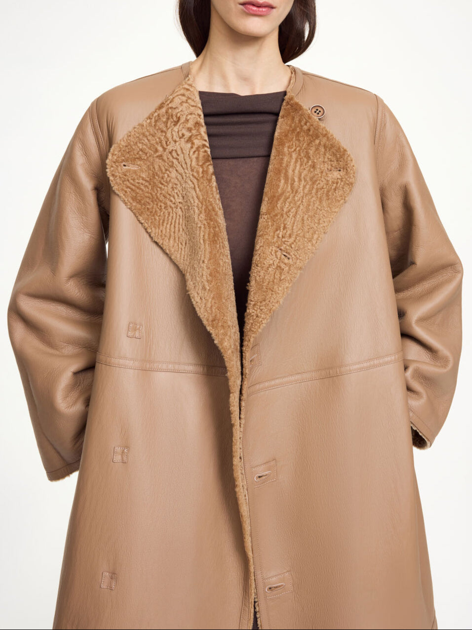 By Malene Birger Sandria lammeskinnskåpe i brun, laget av 100% lammeskinn og pels, med avtagbart belte og maksilengde.