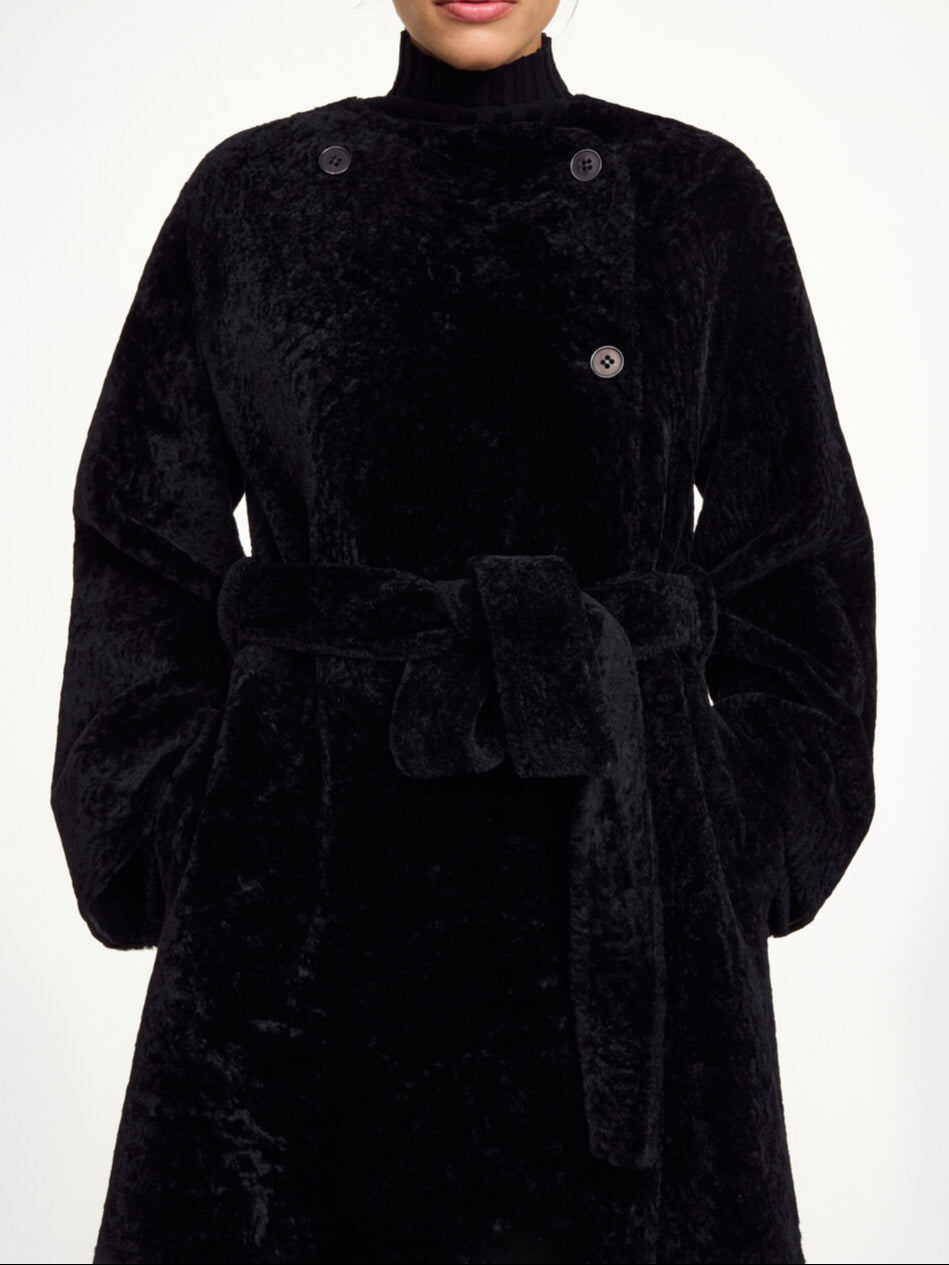 By Malene Birger Sandria lammeskinnskåpe i sort, laget av 100% lammeskinn og pels, med avtagbart belte og maksilengde.