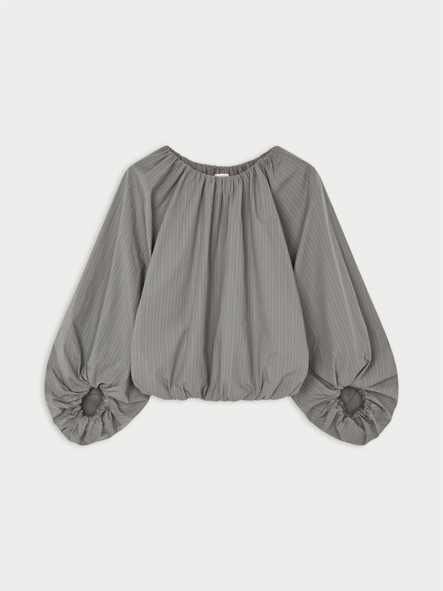 SEMARA bluse fra By Malene Birger i fargen grå, laget i 100% organisk bomull. Raglanermer med ballongfasong, elastisk båthalsinspirert utringning, strikk i mansjettene og cropped lengde.