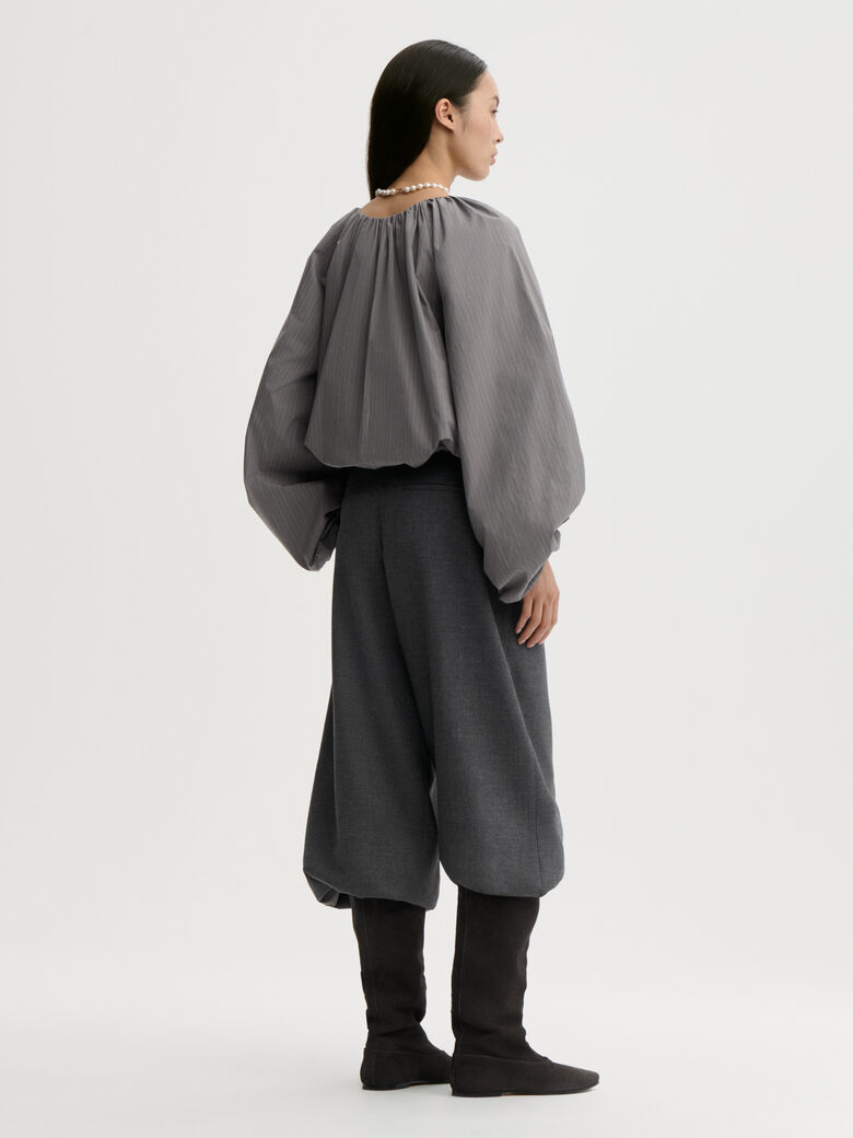SEMARA bluse fra By Malene Birger i fargen grå, laget i 100% organisk bomull. Raglanermer med ballongfasong, elastisk båthalsinspirert utringning, strikk i mansjettene og cropped lengde.