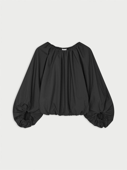 SEMARA bluse fra By Malene Birger i fargen sort, laget i 100% organisk bomull. Raglanermer med ballongfasong, elastisk båthalsinspirert utringning, strikk i mansjettene og cropped lengde.