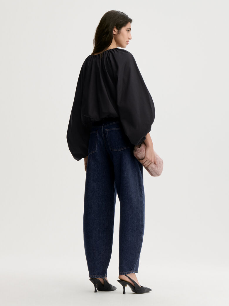 SEMARA bluse fra By Malene Birger i fargen sort, laget i 100% organisk bomull. Raglanermer med ballongfasong, elastisk båthalsinspirert utringning, strikk i mansjettene og cropped lengde.