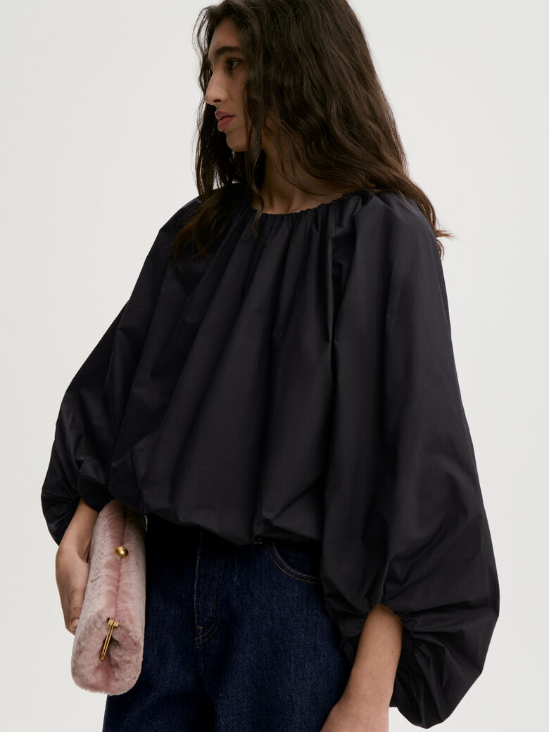 SEMARA bluse fra By Malene Birger i fargen sort, laget i 100% organisk bomull. Raglanermer med ballongfasong, elastisk båthalsinspirert utringning, strikk i mansjettene og cropped lengde.