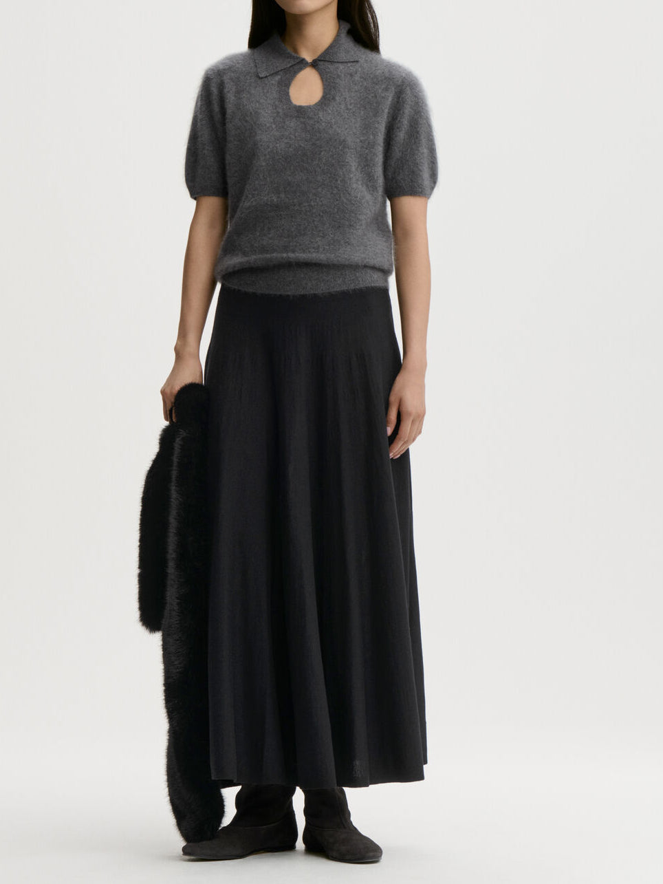 TALALLIA genser fra By Malene Birger i fargen mørkegrå, laget i 100% cashmere. Kortermet med nøkkelhull-utringning som lukkes med knapp, spiss krage og nett passform.