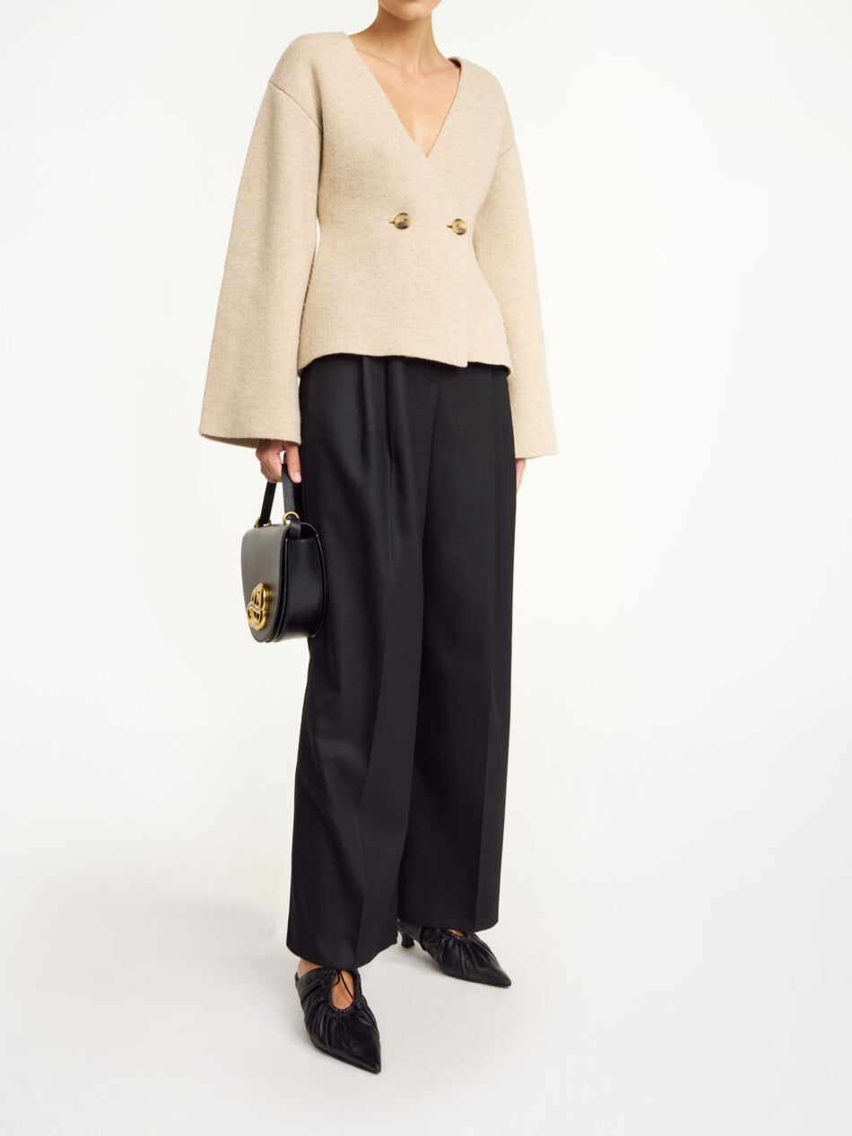 By Malene Birger Tinley cardigan i beige, med et dobbeltspent uttrykk og feminine trompetarmer, laget av ull og elastan.