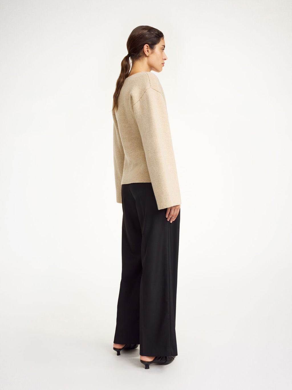 By Malene Birger Tinley cardigan i beige, med et dobbeltspent uttrykk og feminine trompetarmer, laget av ull og elastan.