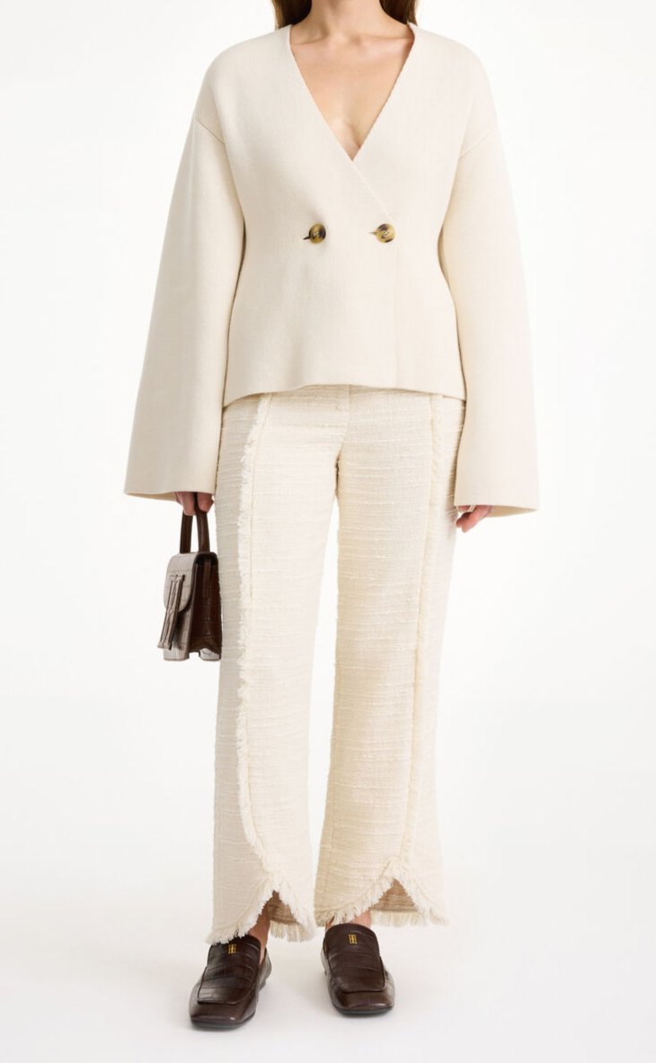 By Malene Birger Tinley cardigan i hvit, med et dobbeltspent uttrykk og feminine trompetarmer, laget av ull, bomull og elastan.