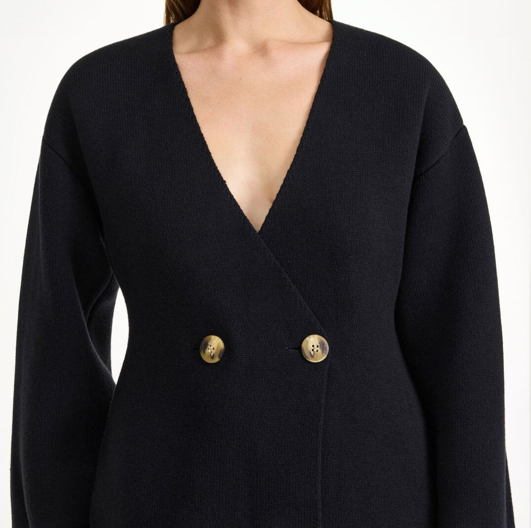 By Malene Birger Tinley cardigan i sort, med et dobbeltspent uttrykk og feminine trompetarmer, laget av ull, bomull og elastan.