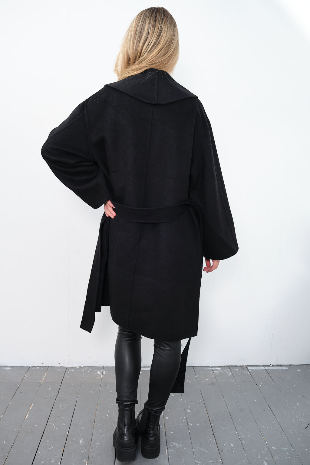 By Malene Birger Trullas kåpe i sort, med en sjal-lignende krage og en rett passform, laget av 100% ull.