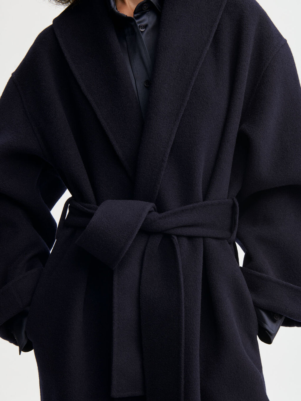 TRULLEM kåpe fra By Malene Birger i fargen mørkeblå, laget i 100% ull. Rett i modellen med sjal-liknende krage/slag og avtagbart belte.