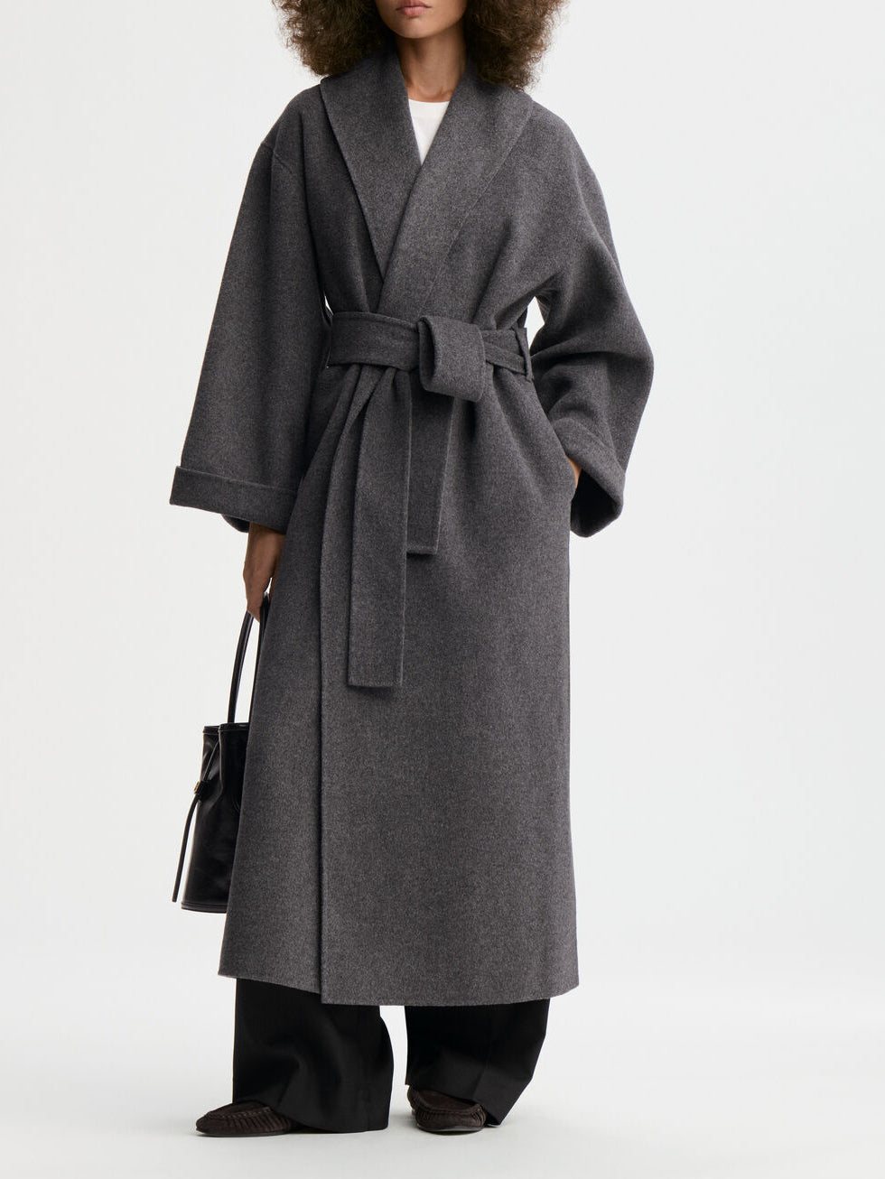 TRULLEM kåpe fra By Malene Birger i fargen mørkegrå, laget i 100% ull. Rett modell med sjal-liknende krage, lommer i siden og avtagbart belte.