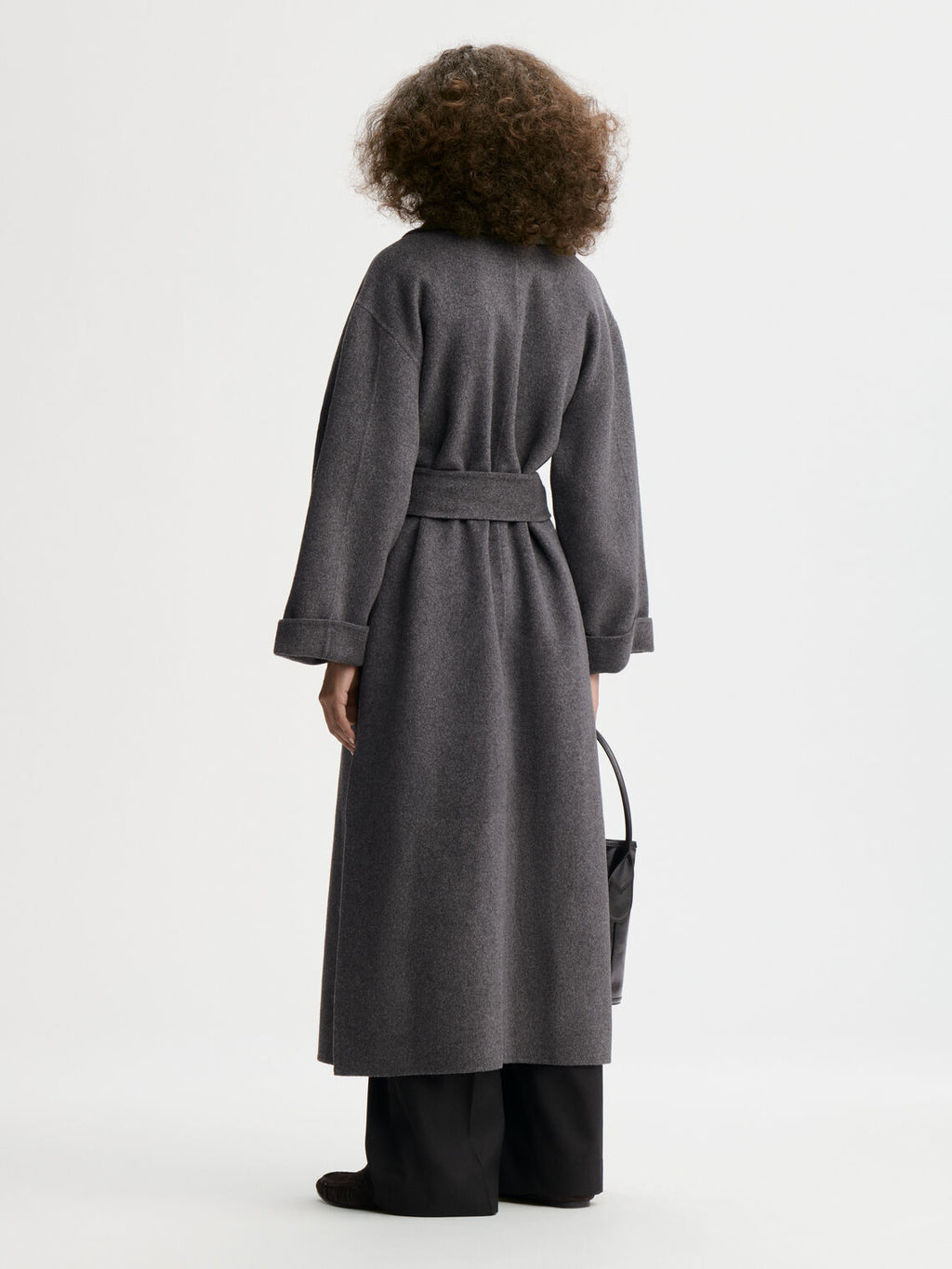 TRULLEM kåpe fra By Malene Birger i fargen mørkegrå, laget i 100% ull. Rett modell med sjal-liknende krage, lommer i siden og avtagbart belte.