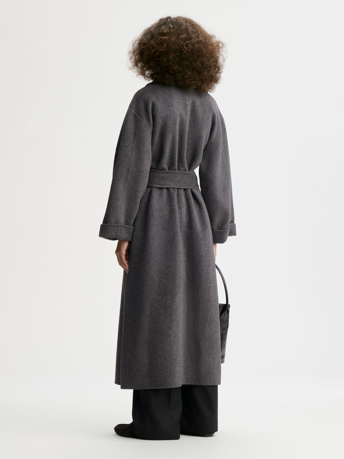 TRULLEM kåpe fra By Malene Birger i fargen mørkegrå, laget i 100% ull. Rett modell med sjal-liknende krage, lommer i siden og avtagbart belte.