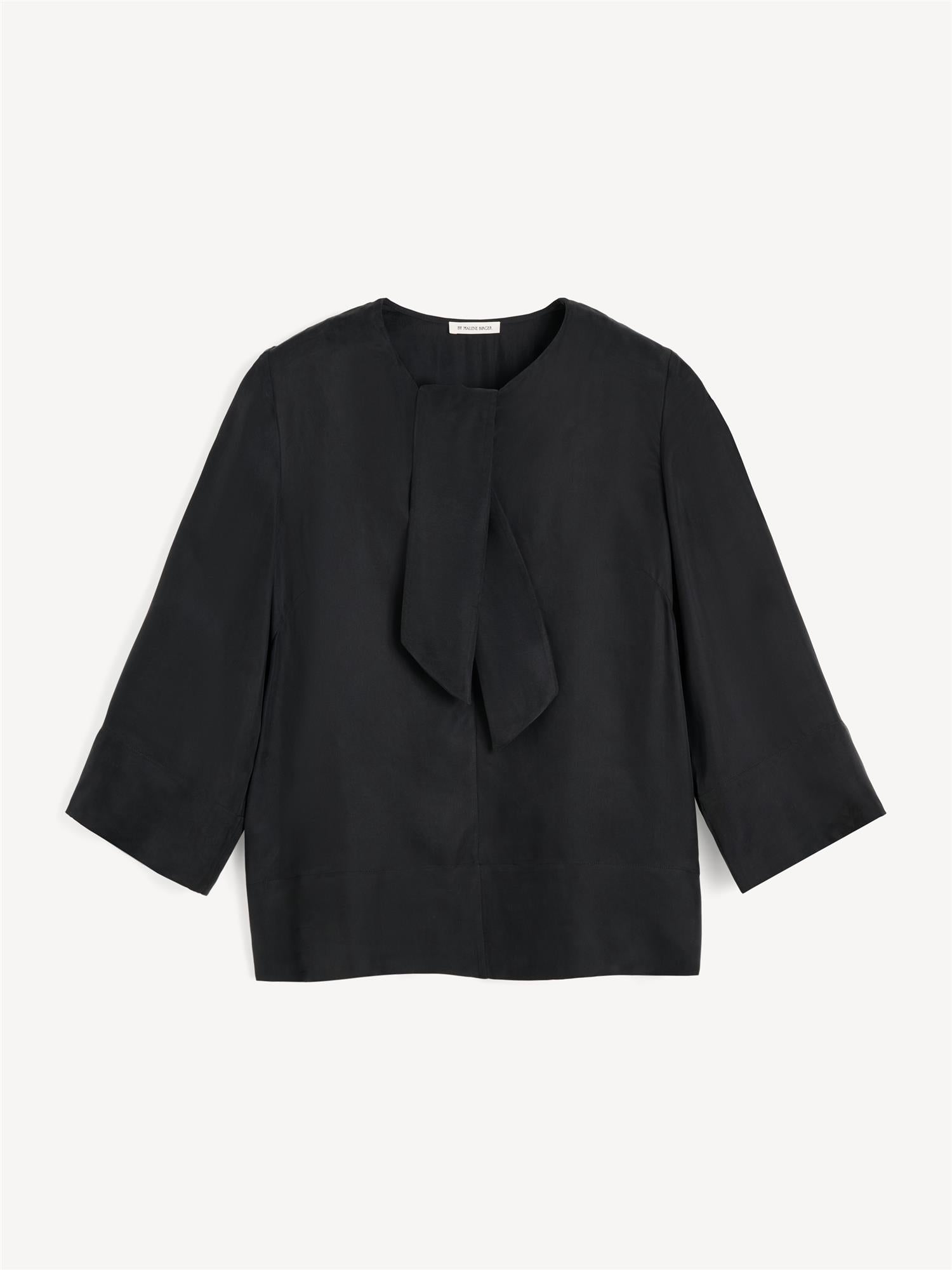 By Malene Birger Vega bluse i sort, med knyting i halsen, en løs passform og laget av en blanding av cupro og viskose.
