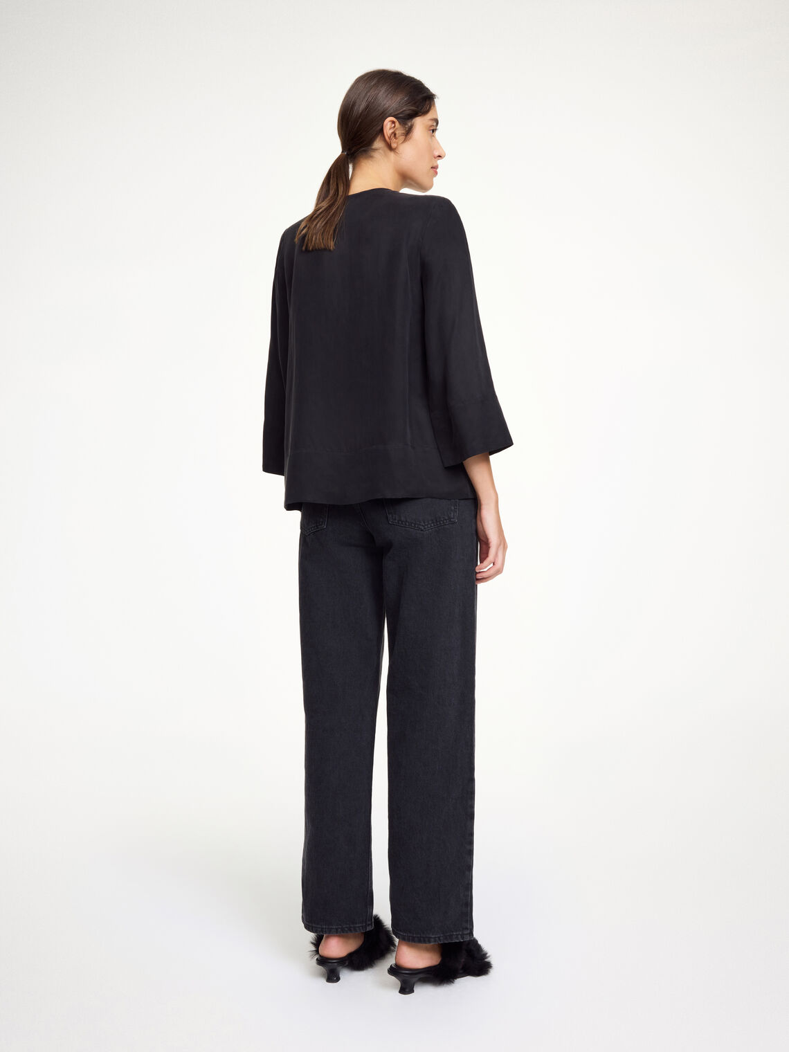 By Malene Birger Vega bluse i sort, med knyting i halsen, en løs passform og laget av en blanding av cupro og viskose.