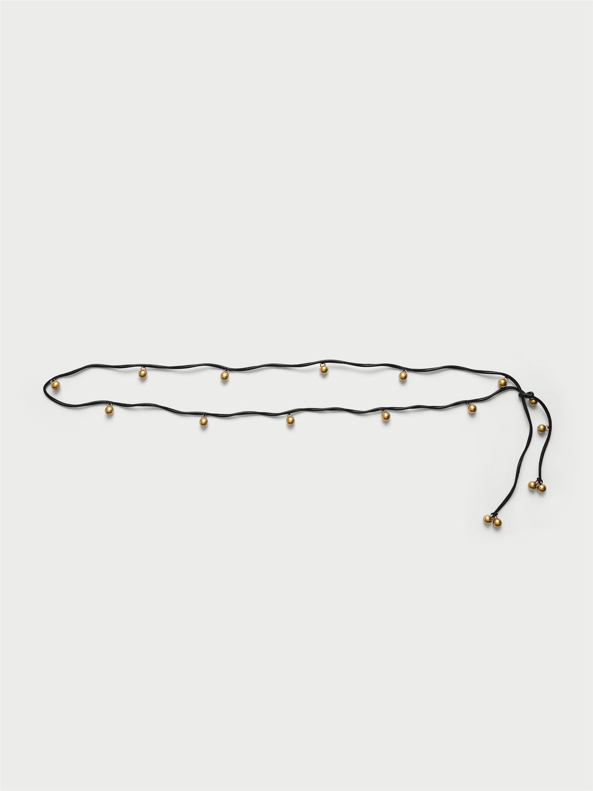 VELLA belte fra By Malene Birger i fargen sort, laget i polyester og polyuretan med justerbar lengde og "gull"-kuler med monogram.