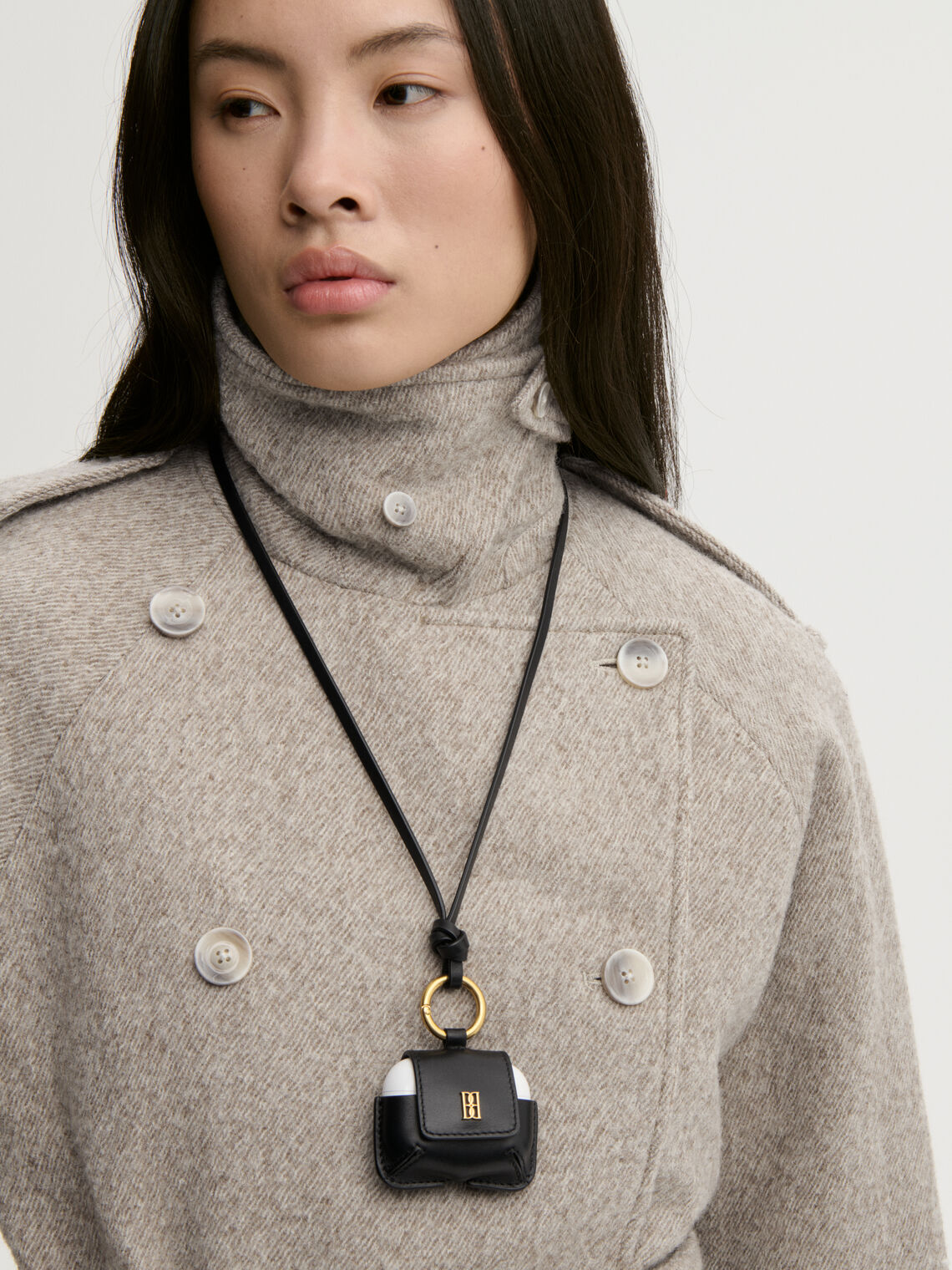 VERA AIRPOD case fra By Malene Birger i fargen sort, laget i skinn. Lukkes med en knapp, har monogram og hull til ladekabel.